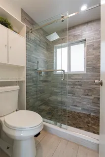 a bathroom with a toilet a sink and shower