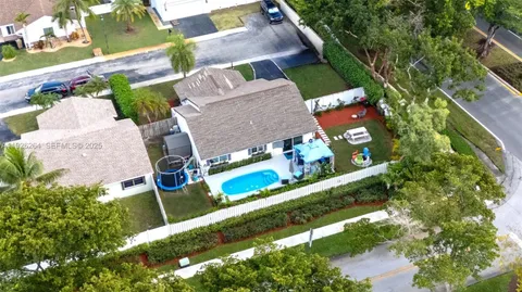 an aerial view of a house with a garden and swimming pool