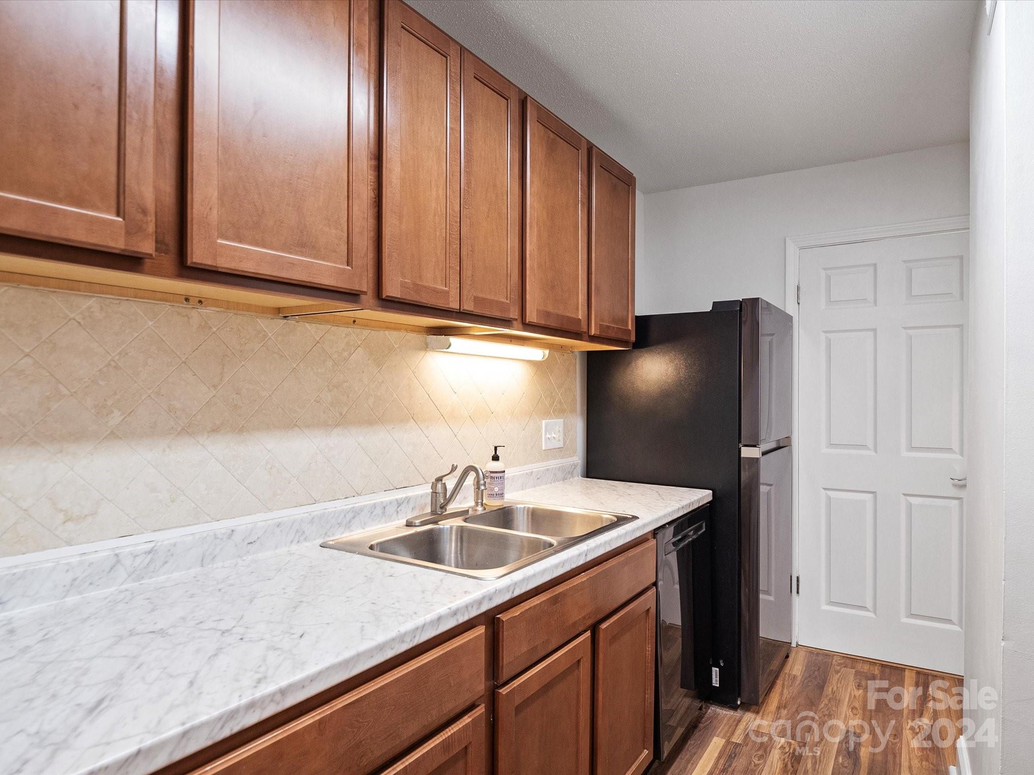 4906 Sardis Road, Unit F Charlotte, NC 28270 - Photo 16 of 30 a kitchen with stainless steel appliances granite countertop a sink a refrigerator and cabinets