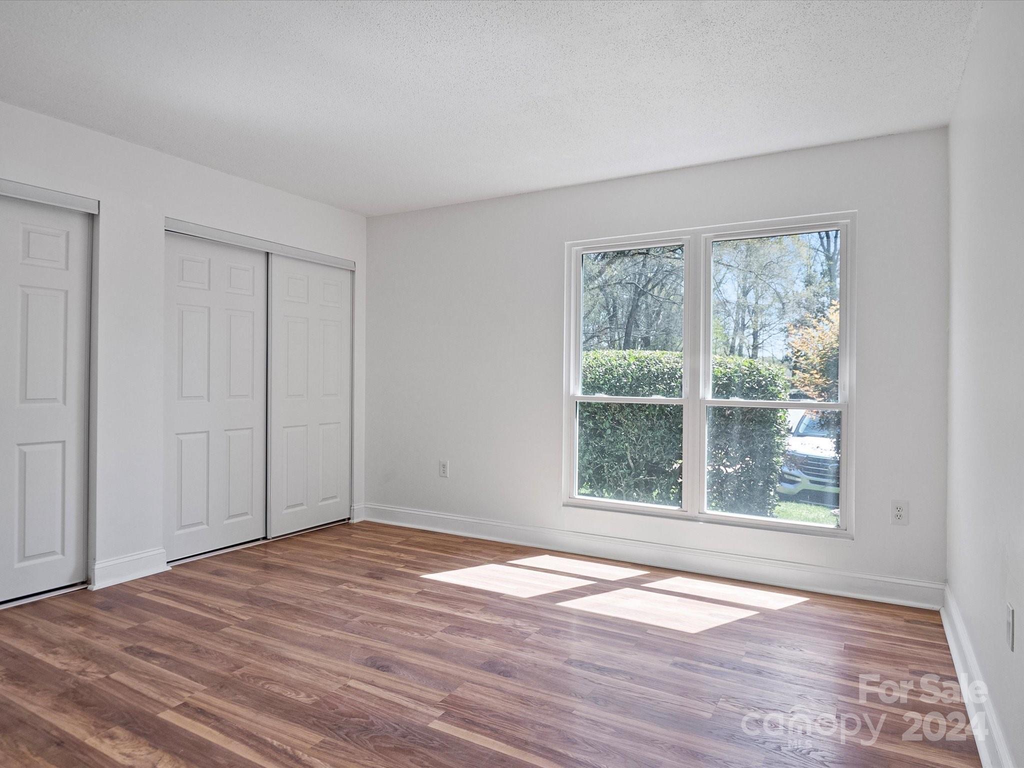 4906 Sardis Road, Unit F Charlotte, NC 28270 - Photo 20 of 30 a view of an empty room with wooden floor and a window