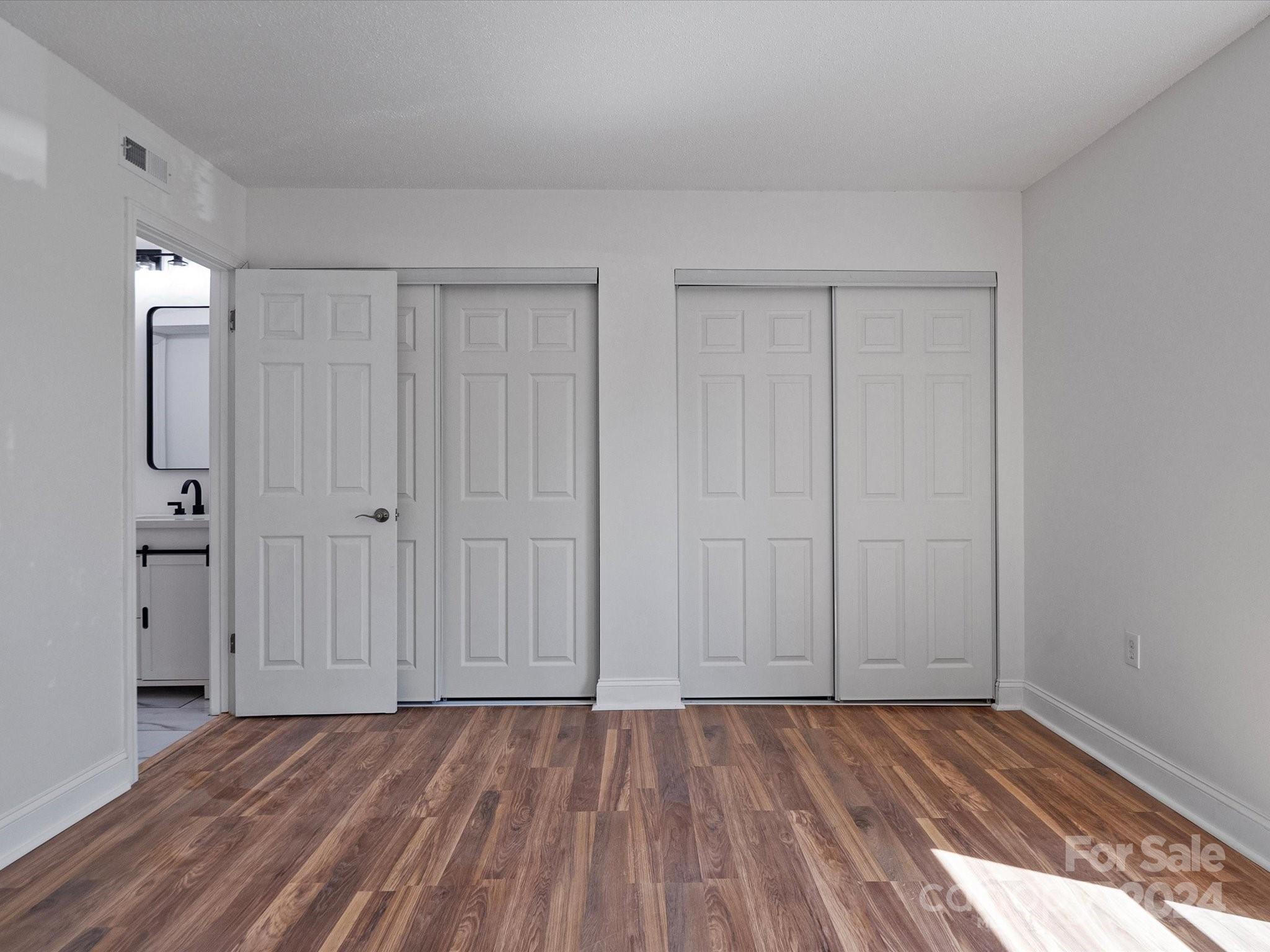4906 Sardis Road, Unit F Charlotte, NC 28270 - Photo 21 of 30 a view of an empty room with wooden floor and a window