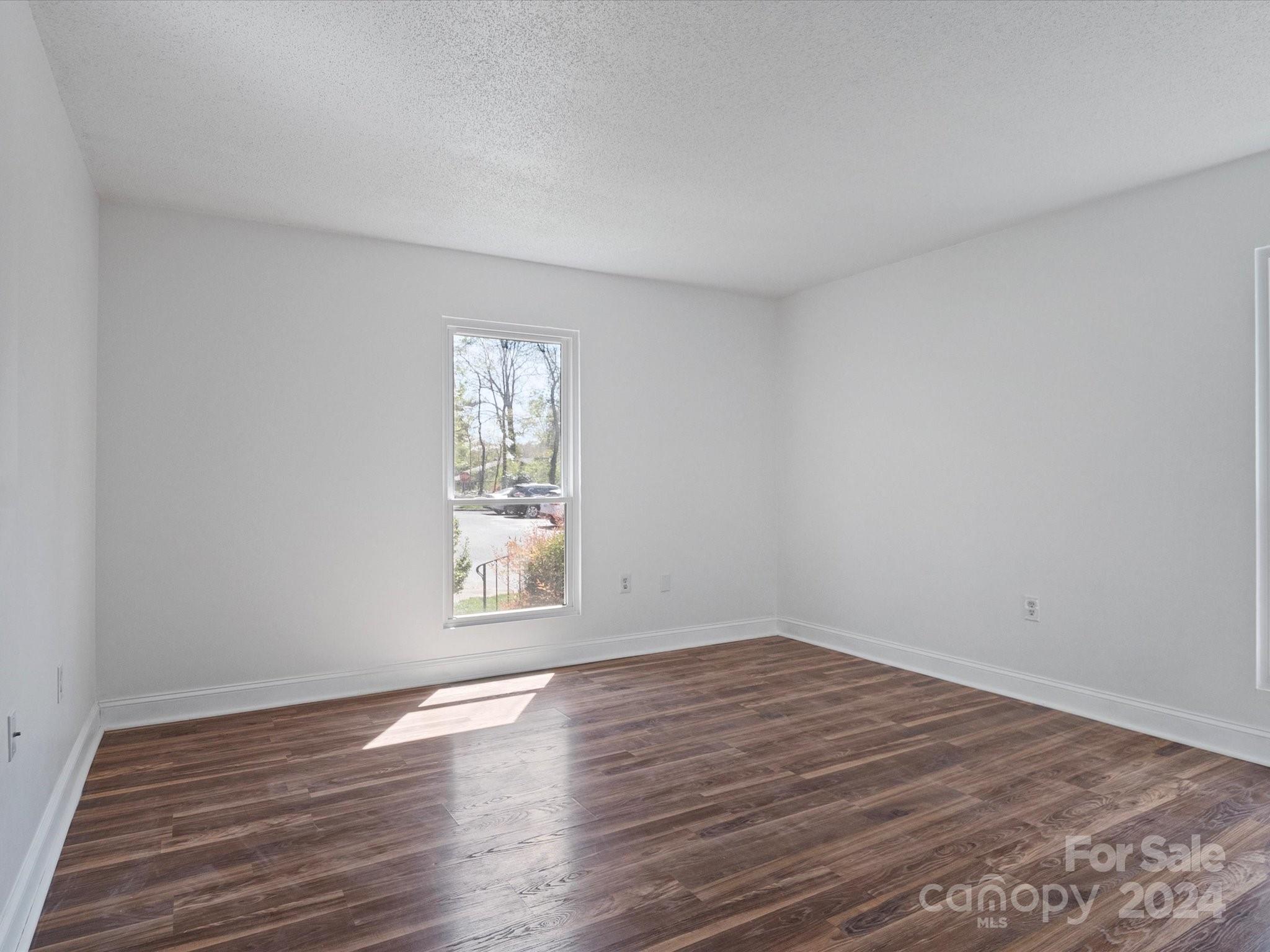 4906 Sardis Road, Unit F Charlotte, NC 28270 - Photo 4 of 30 a view of empty room with wooden floor and fan