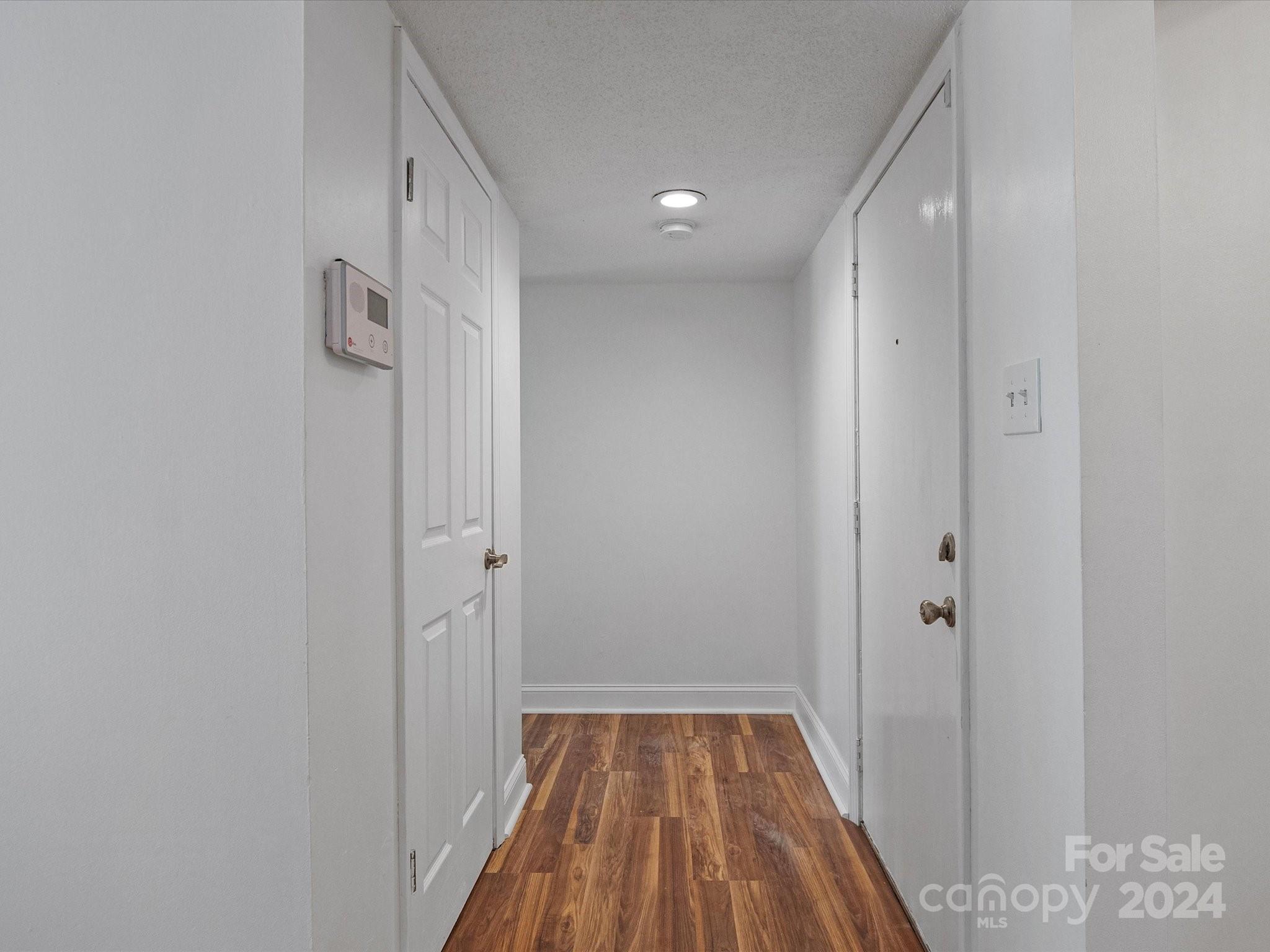 4906 Sardis Road, Unit F Charlotte, NC 28270 - Photo 8 of 30 a view of a hallway with wooden floor and a bathroom