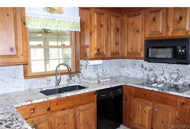 11301 Rochelle Road Chester, VA 23831 - Photo 5 of 17 a kitchen with granite countertop a sink a stove and cabinets