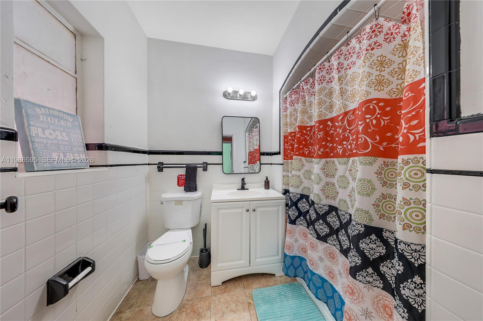 843 Northwest 3rd Street, Unit 1 Miami, FL 33128 - Photo 18 of 26 a white toilet sitting next to a bathroom sink