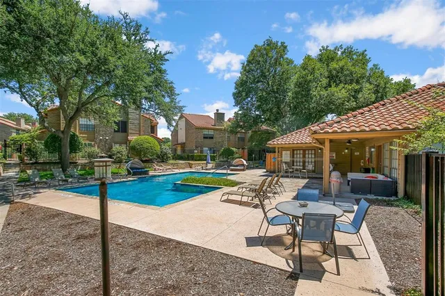 a patio with a table and chairs and potted plants