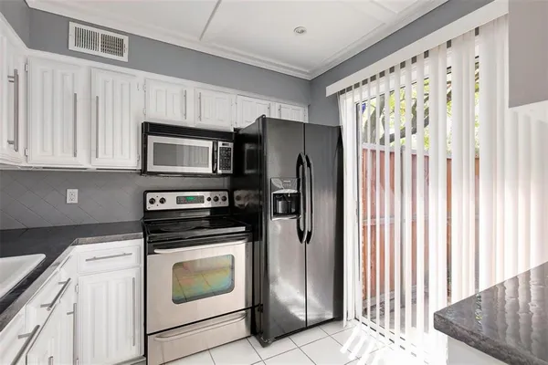 a kitchen with stainless steel appliances granite countertop a refrigerator sink and stove