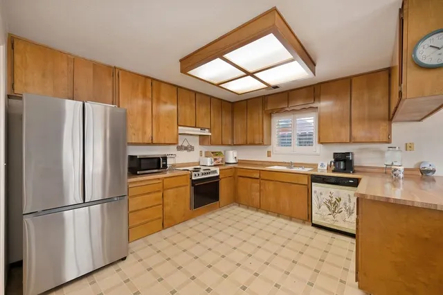 a kitchen with stainless steel appliances granite countertop a refrigerator sink stove microwave and cabinets