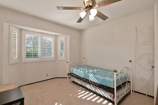 a room with a bed and a ceiling fan