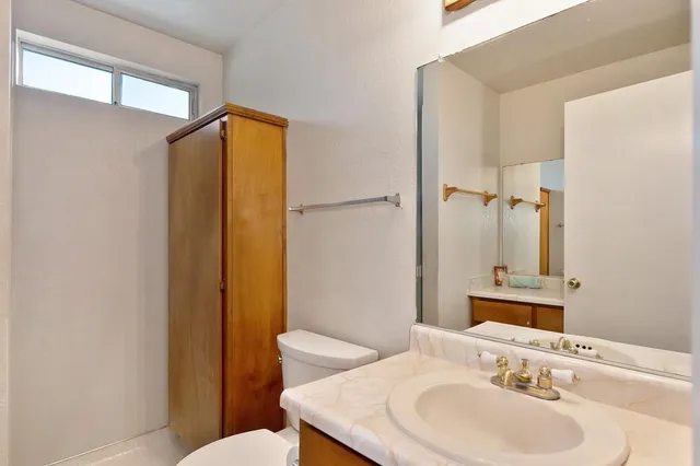 a bathroom with a sink mirror vanity and toilet