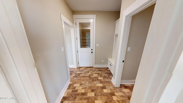 a view of a big room with windows and chandelier fan