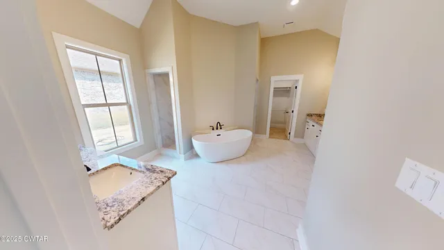 a bathroom with a bathtub sink and mirror