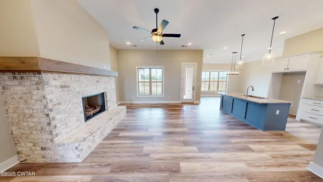 a view of a kitchen with a fireplace and wooden floor