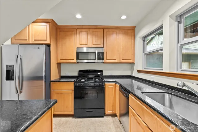a kitchen with stainless steel appliances granite countertop a sink stove and refrigerator