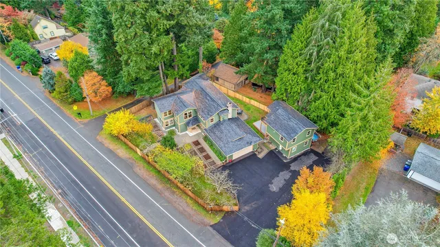 a view of a house with a yard and large trees