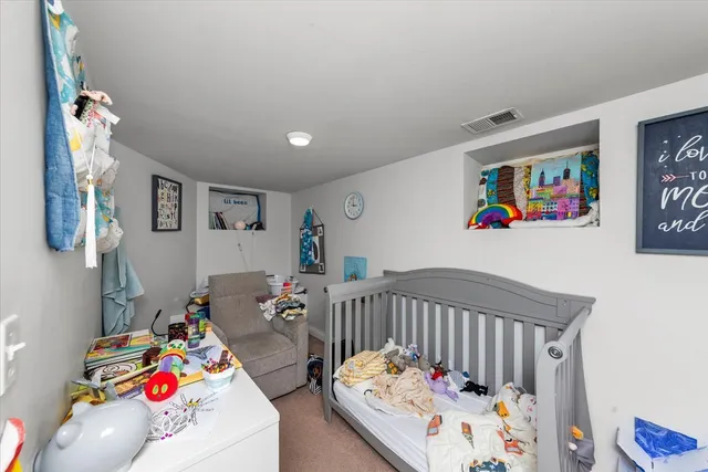 a bedroom with baby bed wooden floor and table