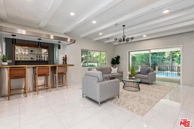 a living room with furniture and a floor to ceiling window