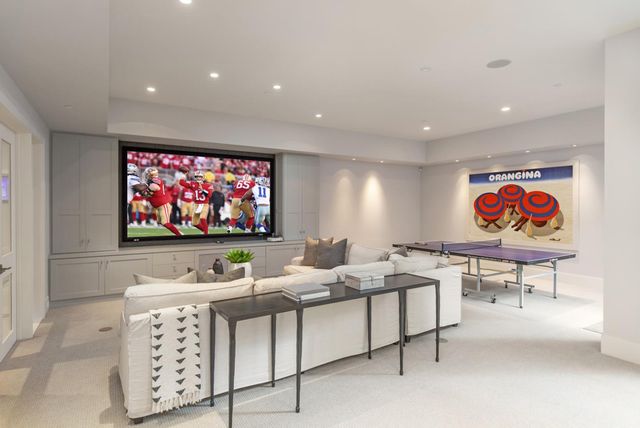 a projector room with furniture a flat screen tv and wall painting