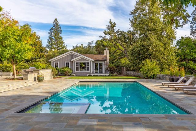 a front view of house with yard and swimming pool
