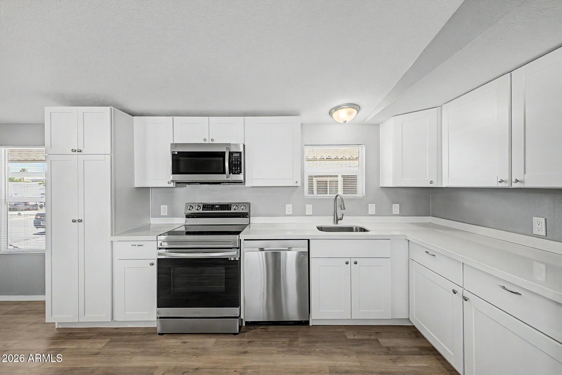 320 East McKellips Road, Unit 58 Mesa, AZ 85201 - Photo 11 of 22 a kitchen with granite countertop white cabinets and stainless steel appliances