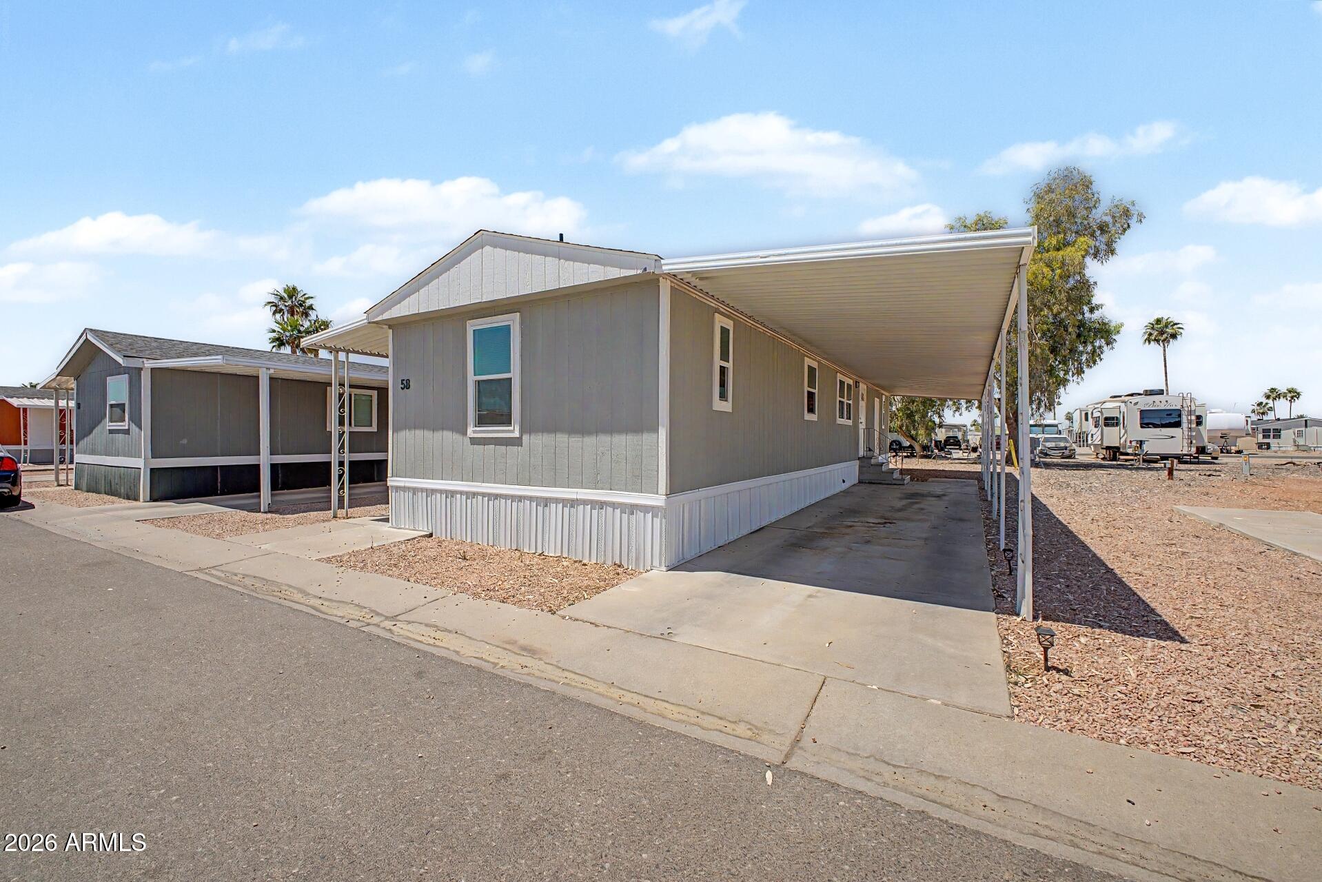 320 East McKellips Road, Unit 58 Mesa, AZ 85201 - Photo 2 of 22 a view of a house with a parking space and a garage