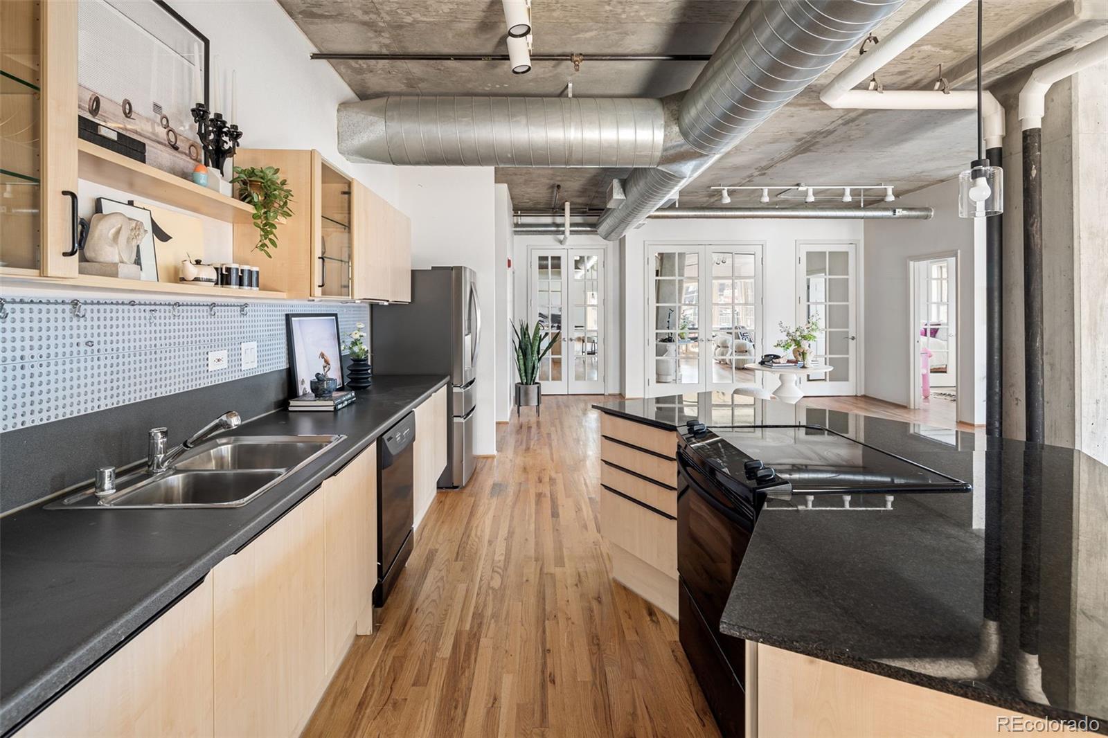 1499 Blake Street, Unit 6A Denver, CO 80202 - Photo 22 of 46 a kitchen with granite countertop a sink stove and refrigerator