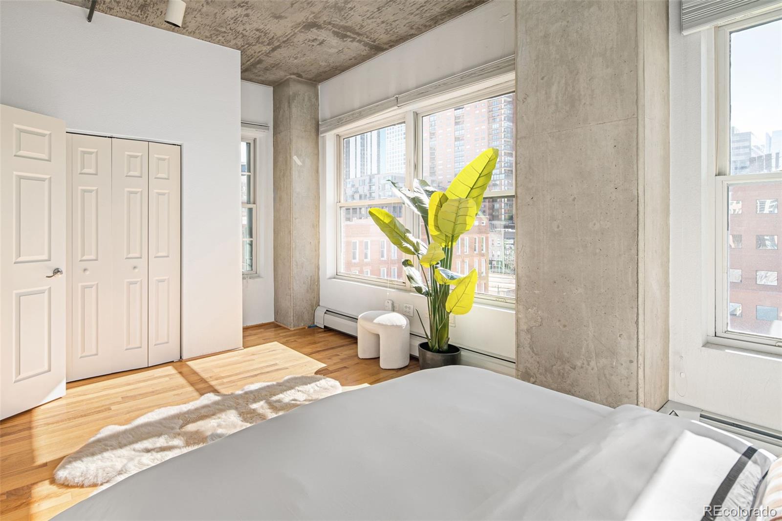 1499 Blake Street, Unit 6A Denver, CO 80202 - Photo 26 of 46 a bedroom with a bed a window and couch