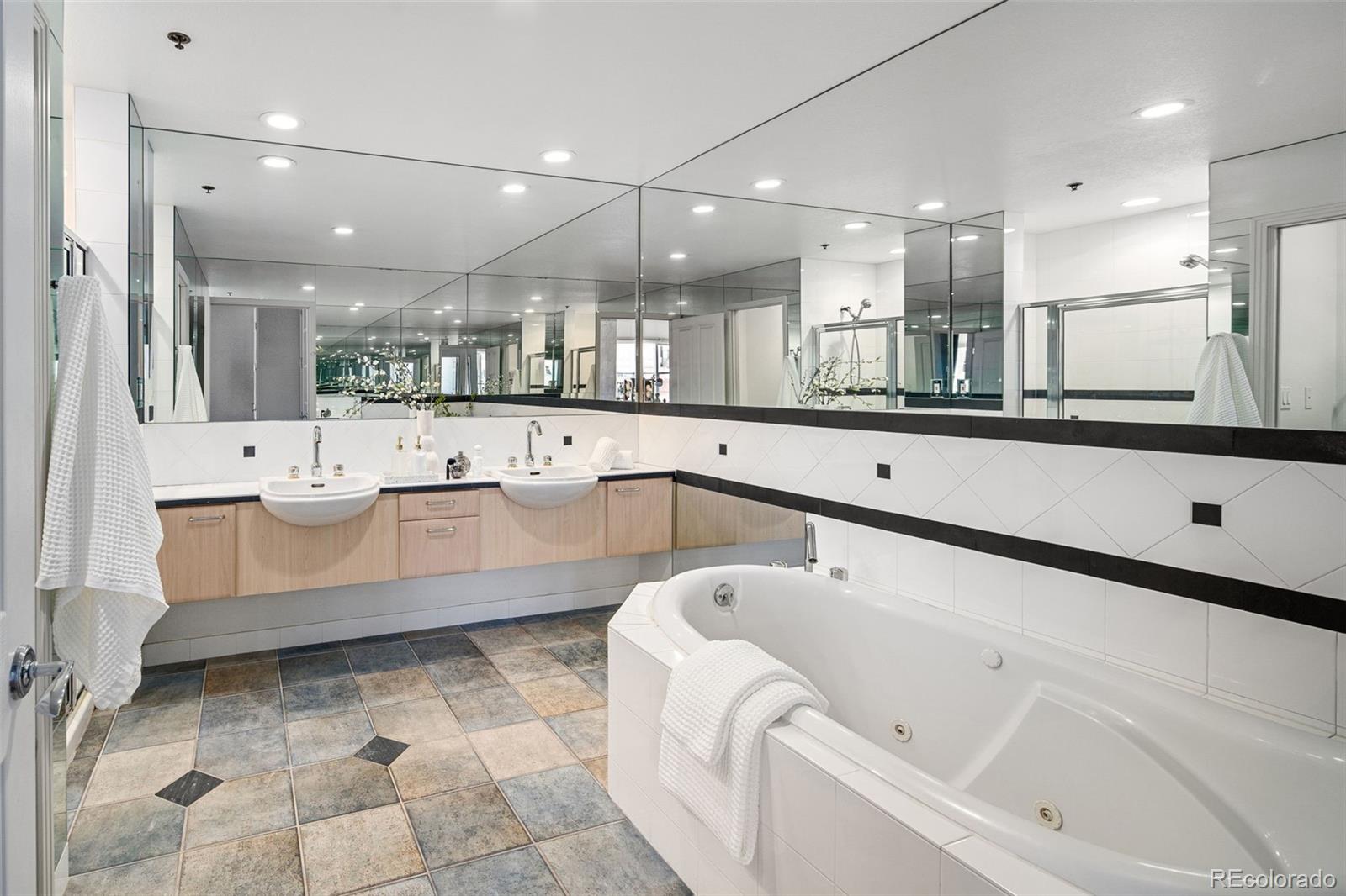 1499 Blake Street, Unit 6A Denver, CO 80202 - Photo 28 of 46 a large white kitchen with a large counter top a sink stainless steel appliances and cabinets