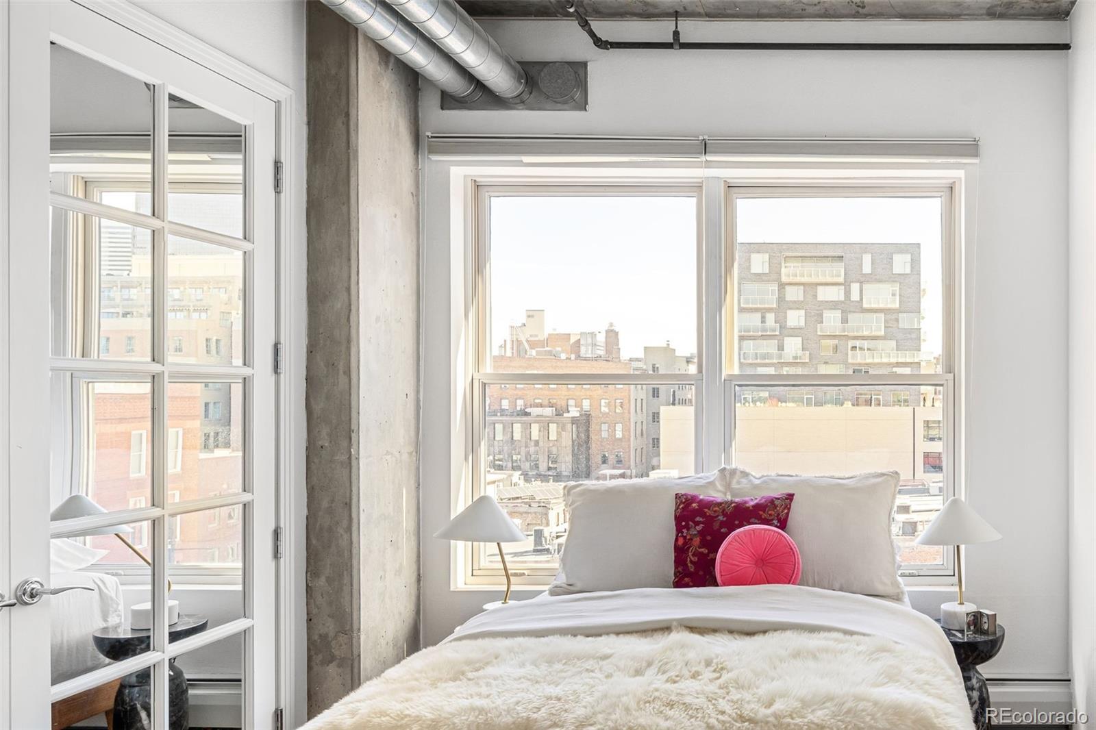 1499 Blake Street, Unit 6A Denver, CO 80202 - Photo 30 of 46 a bedroom with a large bed and glass window