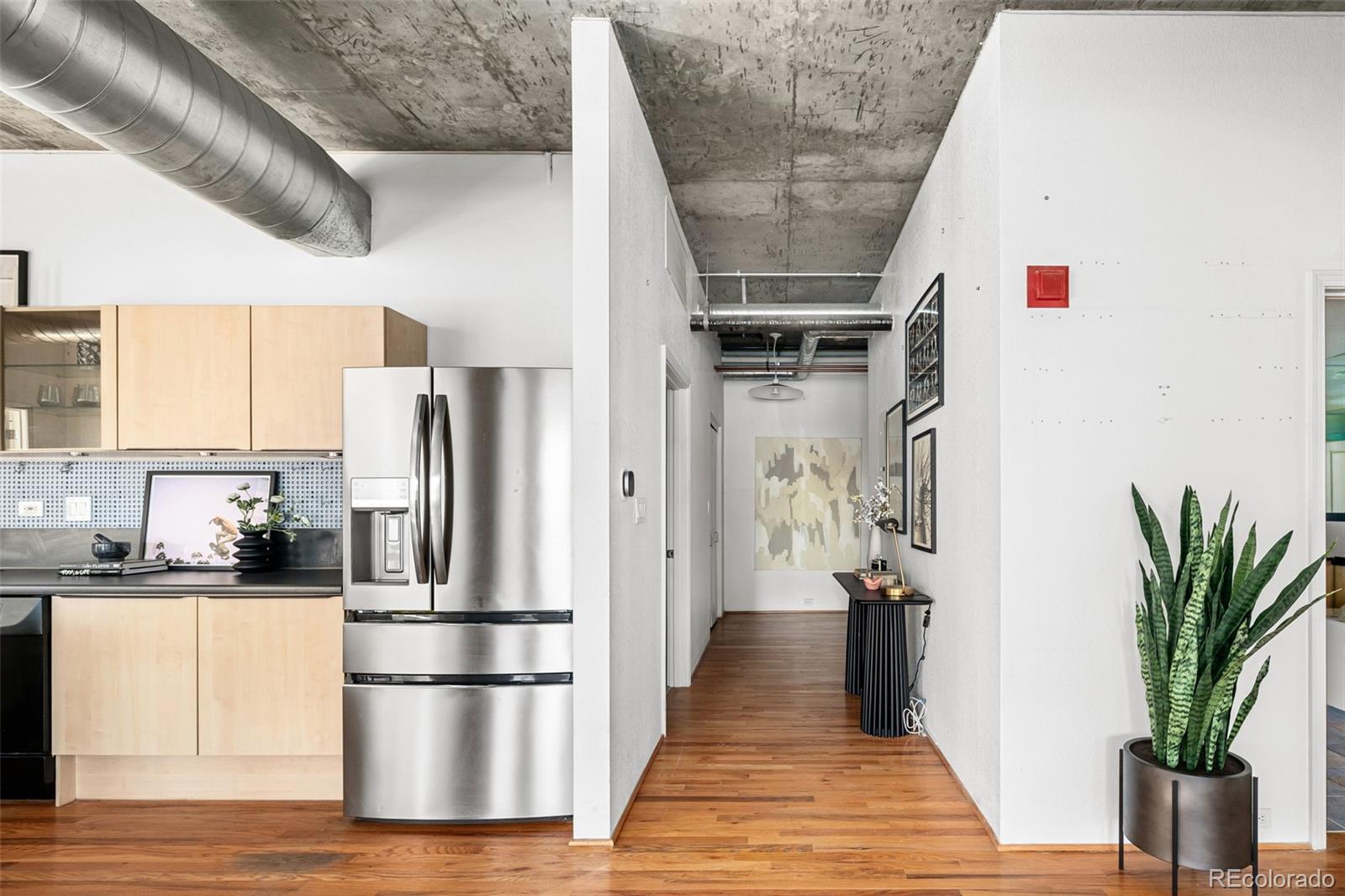 1499 Blake Street, Unit 6A Denver, CO 80202 - Photo 4 of 46 a kitchen with stainless steel appliances a refrigerator and wooden floor
