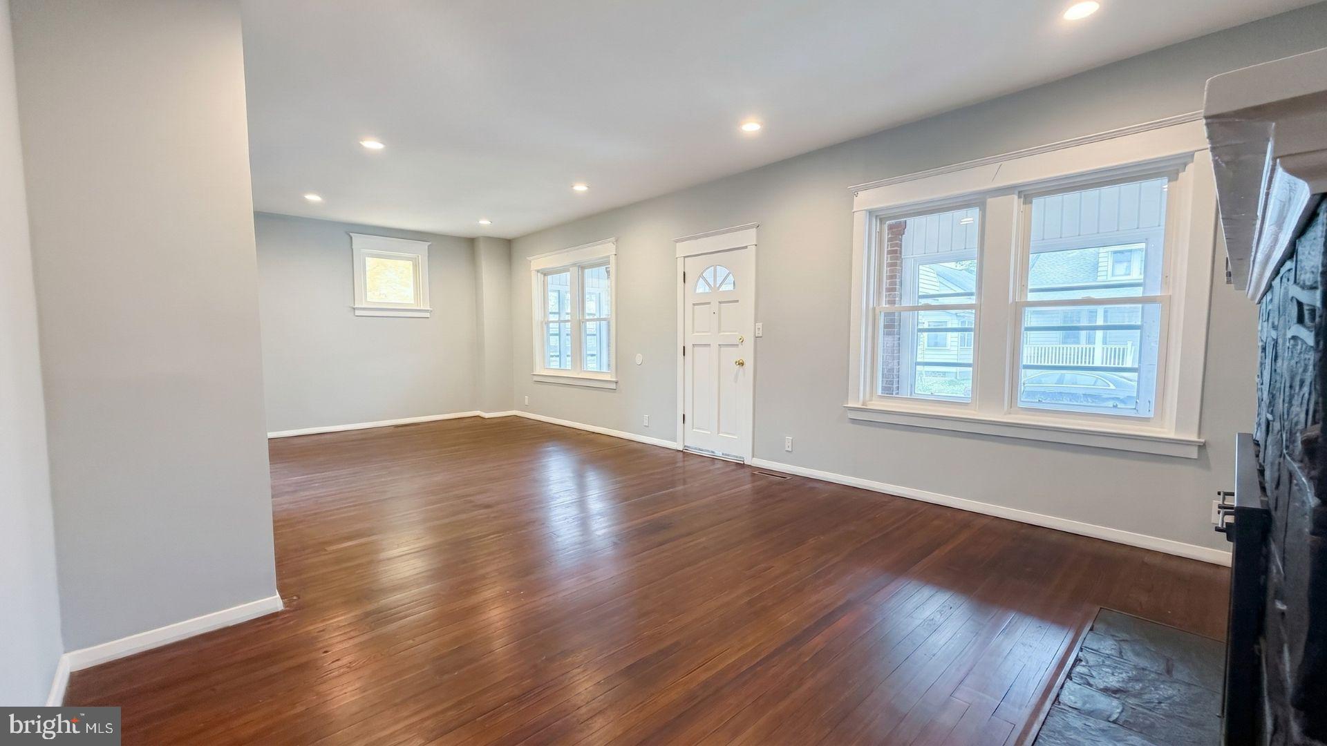 154 Andrew Street Hamilton, NJ 08610 - Photo 5 of 29 an empty room with wooden floor and windows with curtains view
