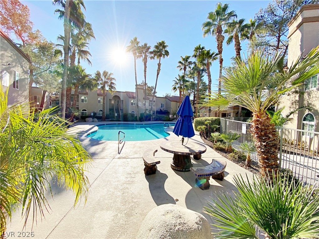 3145 East Flamingo Road, Unit 1128 Las Vegas, NV 89121 - Photo 17 of 19 An inviting pool area surrounded by lush palms, perfect for relaxation and recreation.