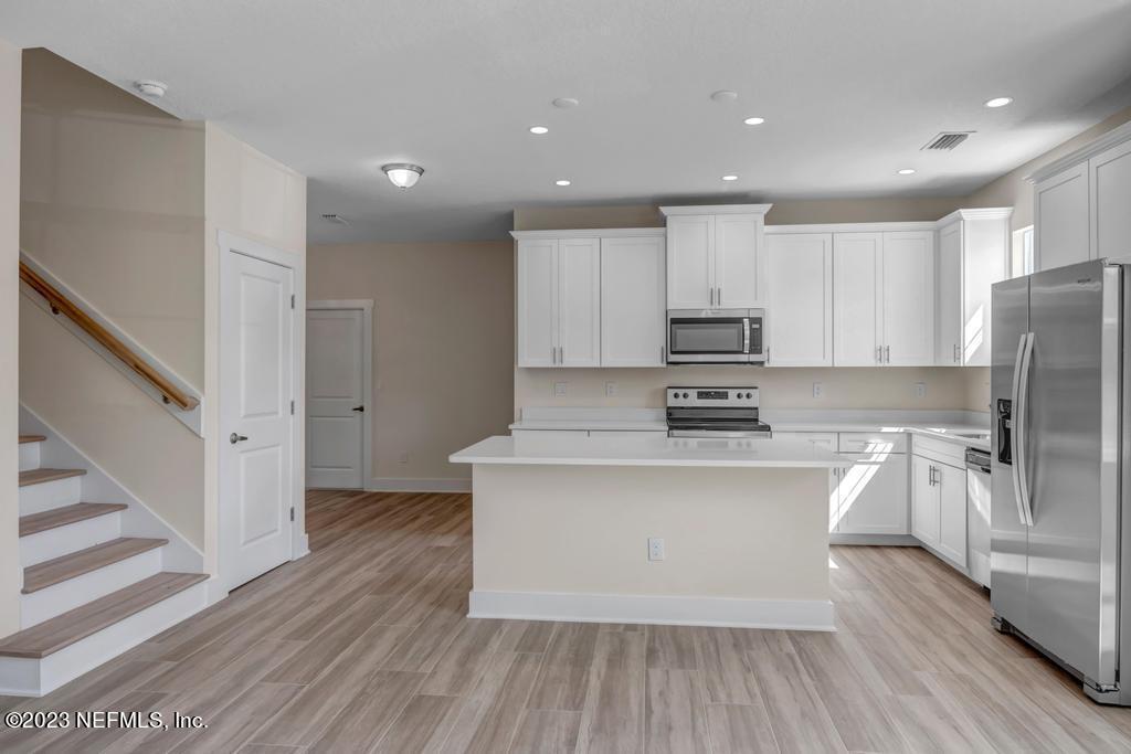 3666 Eunice Road Jacksonville, FL 32250 - Photo 11 of 32 a large kitchen with stainless steel appliances granite countertop a stove a sink and a refrigerator