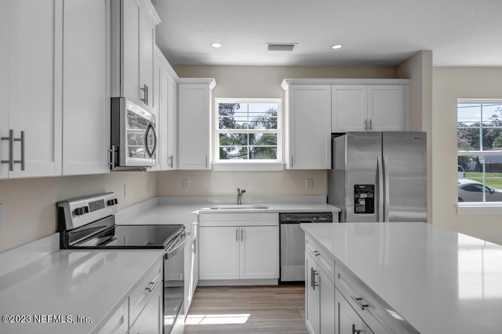 3666 Eunice Road Jacksonville, FL 32250 - Photo 13 of 32 a kitchen with stainless steel appliances granite countertop a sink stove and refrigerator