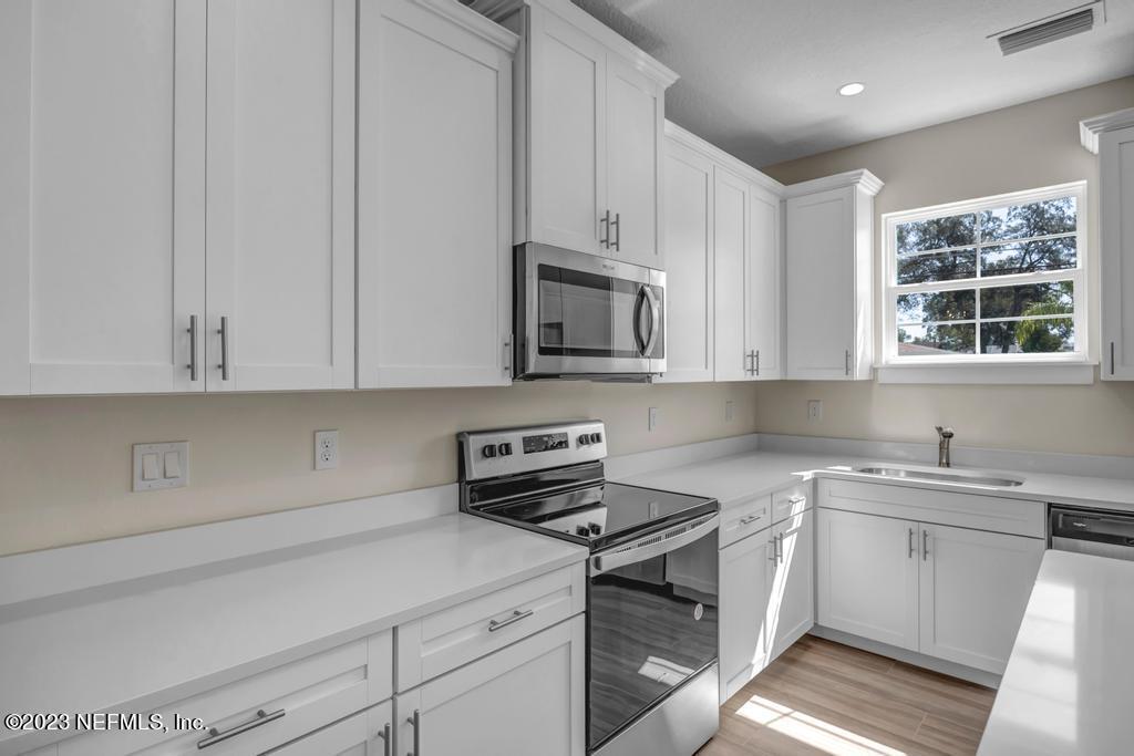 3666 Eunice Road Jacksonville, FL 32250 - Photo 14 of 32 a kitchen with stainless steel appliances granite countertop a sink a stove and a microwave