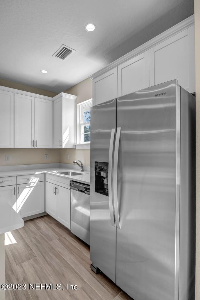 3666 Eunice Road Jacksonville, FL 32250 - Photo 15 of 32 a kitchen with a refrigerator and white cabinets