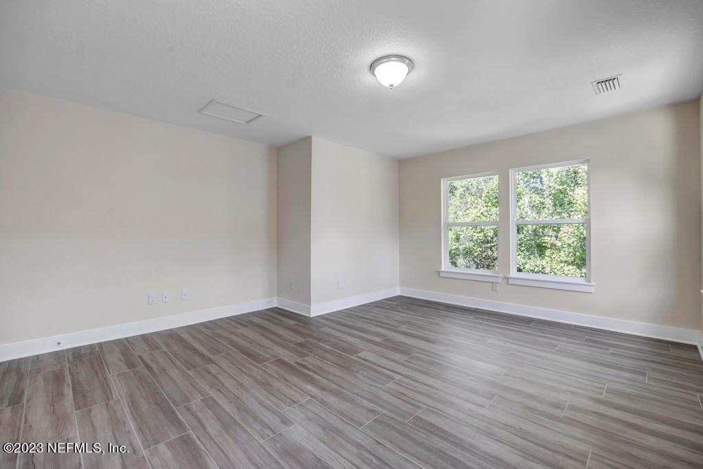 3666 Eunice Road Jacksonville, FL 32250 - Photo 22 of 32 an empty room with wooden floor and windows