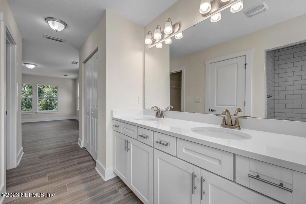 3666 Eunice Road Jacksonville, FL 32250 - Photo 25 of 32 a bathroom with a double vanity sink and a mirror