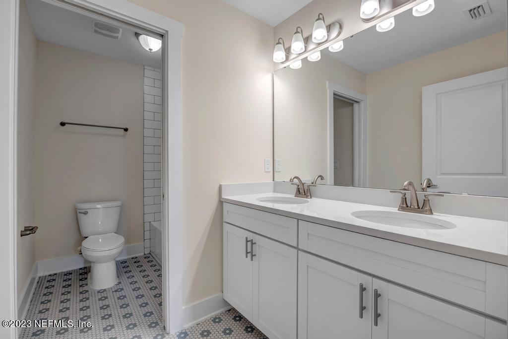 3666 Eunice Road Jacksonville, FL 32250 - Photo 30 of 32 a bathroom with a toilet sink and a mirror