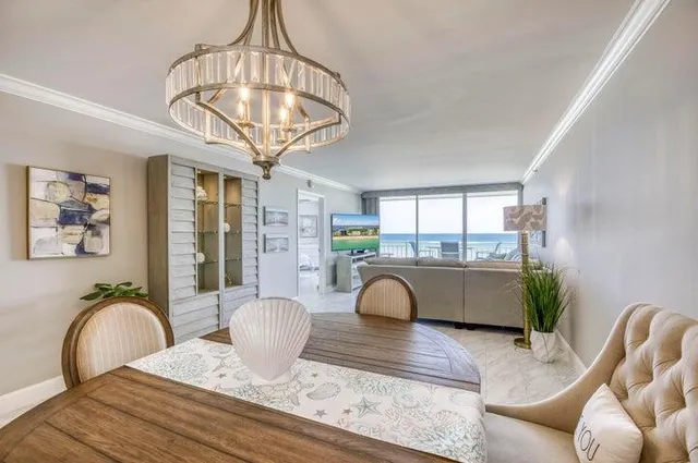 a living room with furniture a chandelier and a large window