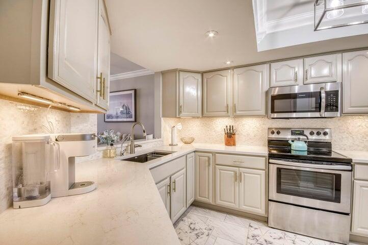 9600 South Ocean Drive, Unit 306 Jensen Beach, FL 34957 - Photo 15 of 36 a kitchen with a sink stove and microwave