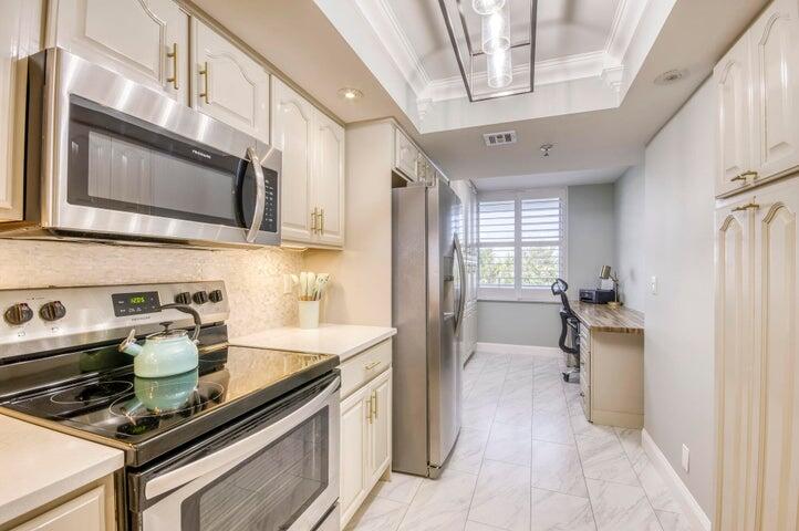 9600 South Ocean Drive, Unit 306 Jensen Beach, FL 34957 - Photo 16 of 36 a kitchen with stainless steel appliances a stove a sink and a refrigerator
