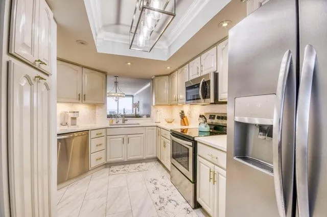 a kitchen with stainless steel appliances granite countertop a refrigerator a stove top oven a sink and dishwasher