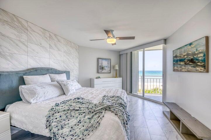 9600 South Ocean Drive, Unit 306 Jensen Beach, FL 34957 - Photo 20 of 36 a spacious bedroom with a large bed and a chandelier