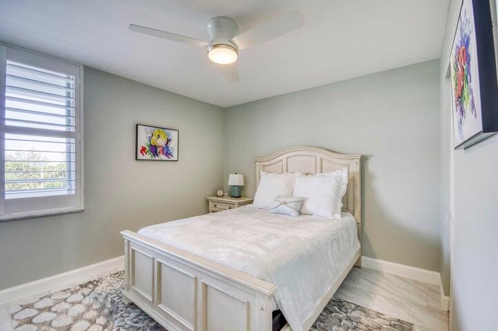 9600 South Ocean Drive, Unit 306 Jensen Beach, FL 34957 - Photo 26 of 36 a bedroom with a bed and a chandelier