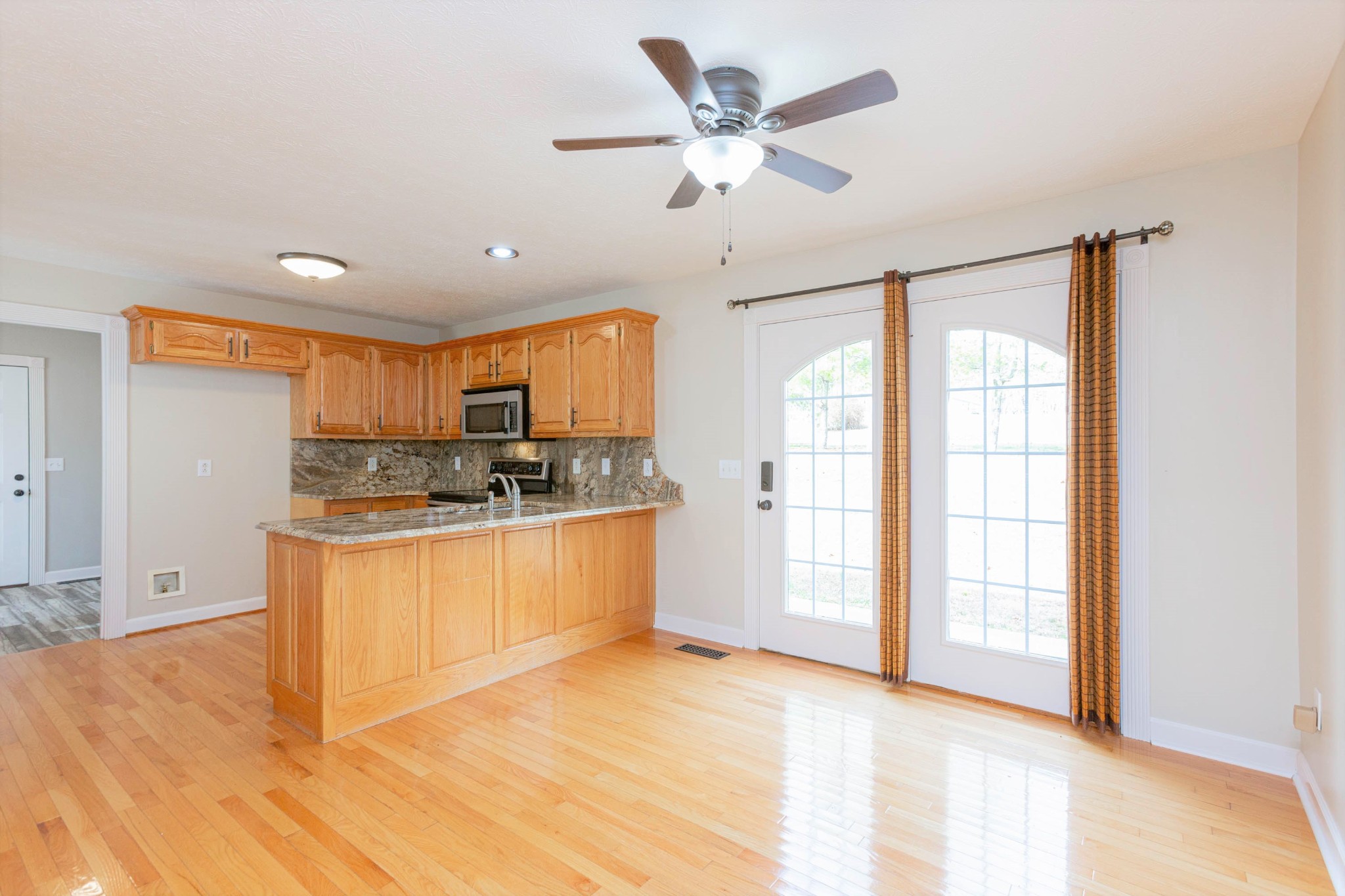 122 Boiling Springs Road Portland, TN 37148 - Photo 4 of 27 a large kitchen with stainless steel appliances granite countertop a refrigerator a sink dishwasher a stove and white cabinets with wooden floor