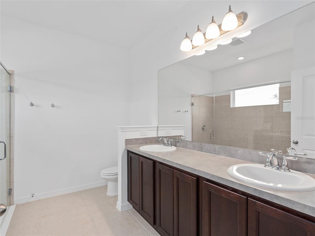 1122 Pearl Tree Road Deltona, FL 32725 - Photo 13 of 30 a bathroom with a sink a large mirror and a light fixture