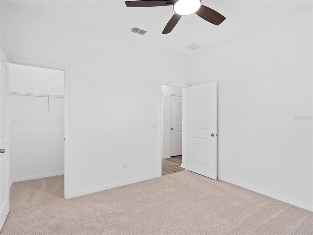 1122 Pearl Tree Road Deltona, FL 32725 - Photo 21 of 30 an empty room with a ceiling fan and carpet
