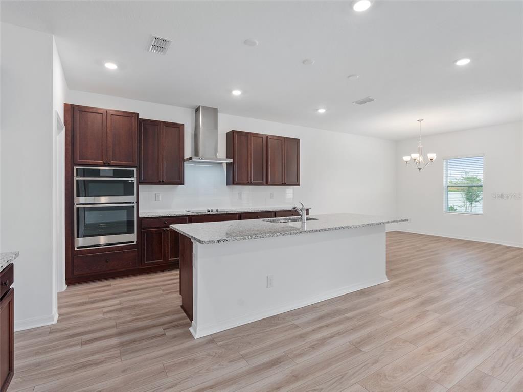 1122 Pearl Tree Road Deltona, FL 32725 - Photo 5 of 30 a kitchen with stainless steel appliances granite countertop a stove a sink and a refrigerator