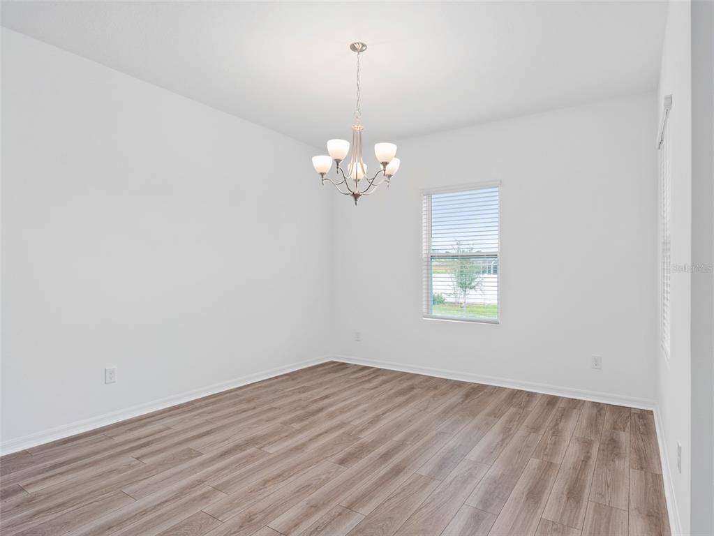 1122 Pearl Tree Road Deltona, FL 32725 - Photo 7 of 30 wooden floor in an empty room with a window
